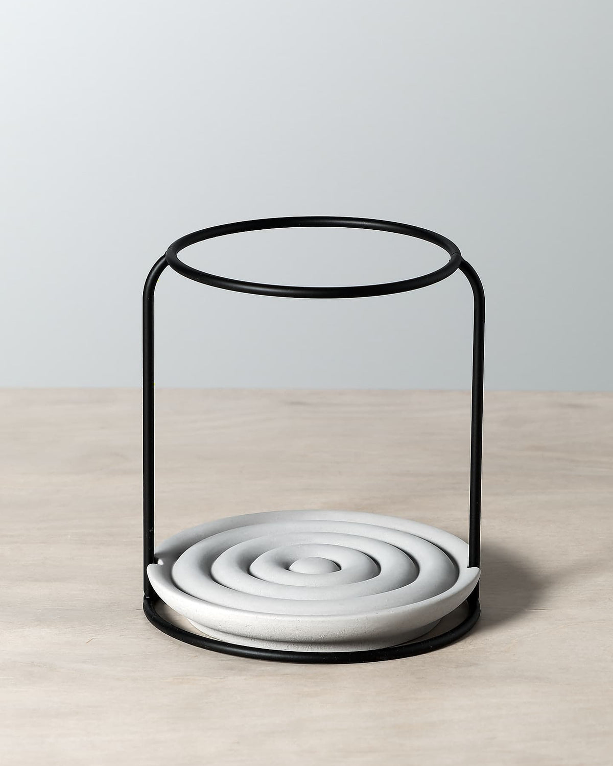 An Iris Hantverk grey dish brush holder on a wooden table.