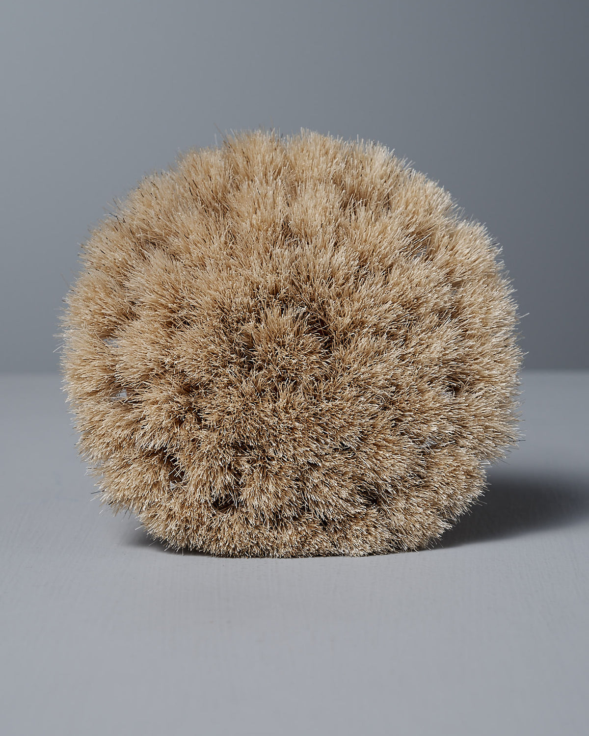 The Duck Bath Brush – Soft by Iris Hantverk, adorned with dense beige horse hair bristles, stands elegantly against a gray background, epitomizing timeless quality.