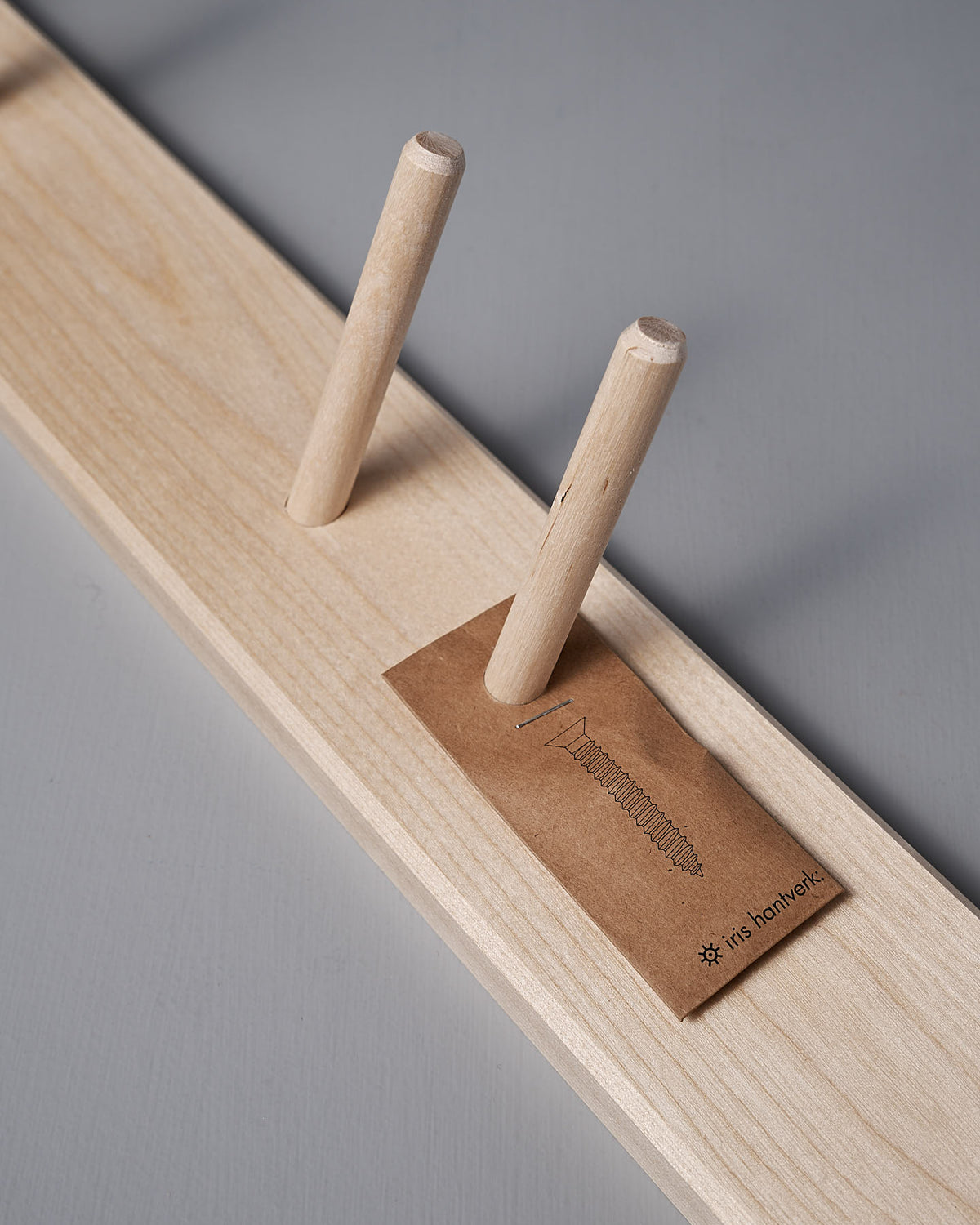 Birchwood Garden Tool Hanger by Iris Hantverk, featuring two vertical dowels and a small card labeled "It's Handmade," highlighting its Shaker-inspired design.