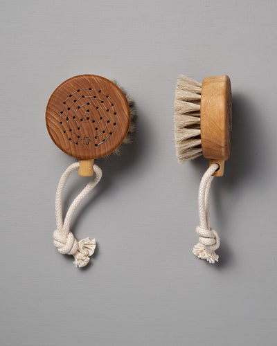 Two Puck Bath Brushes from Iris Hantverk, featuring horsehair bristles and knotted rope handles, are elegantly displayed against a gray background. These remarkable items reflect the exceptional craftsmanship associated with Iris Hantverk.