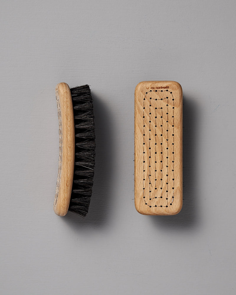 Two Iris Hantverk Shoe Brushes made from beech wood and featuring horse hair bristles, one viewed from the side and the other from the top, set against a gray background.