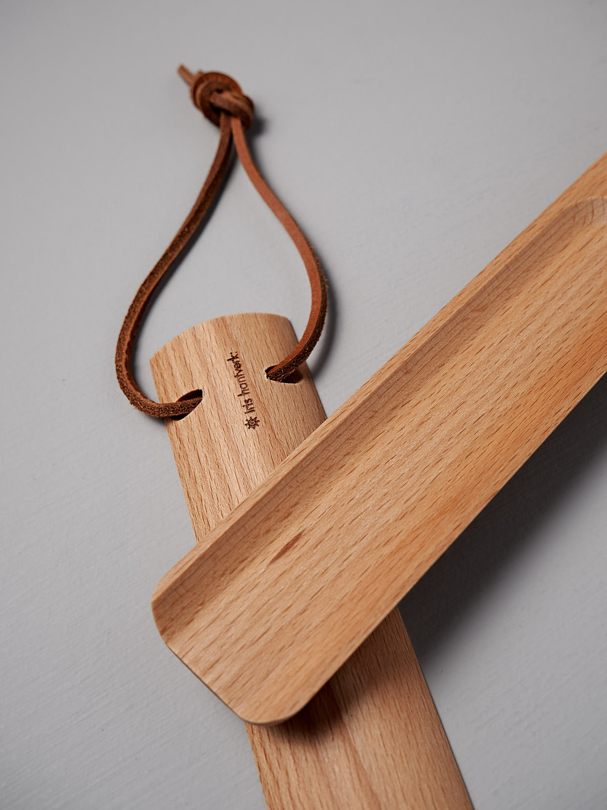 The Iris Hantverk Shoe Horn – Short ⋄ Long, made from oiled beech, includes a handy leather loop for hanging.