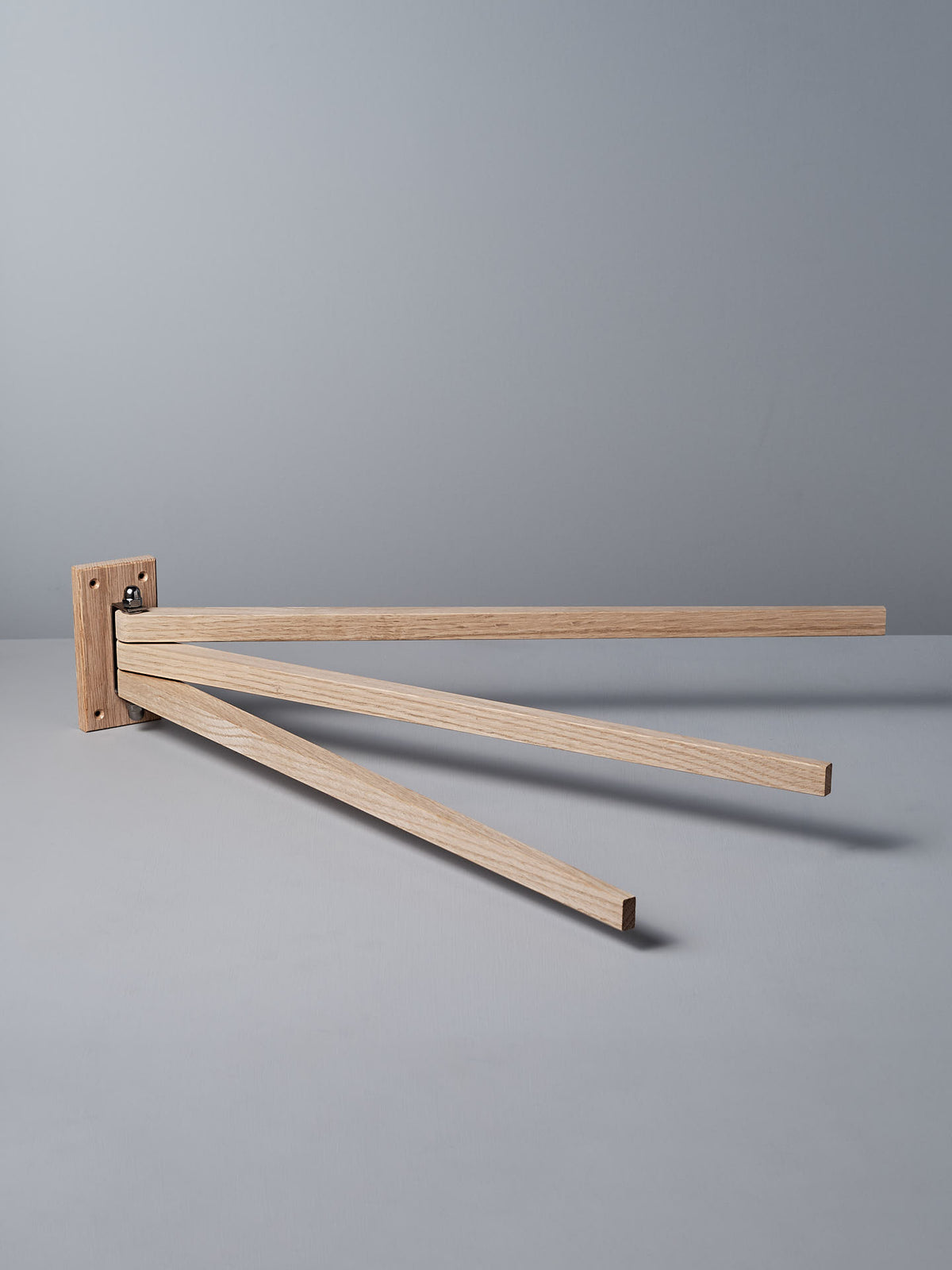 The Oak Towel Drying Rack – 3 Arm by Iris Hantverk showcases an elegant design with three outward-extended horizontal arms, crafted from fine oak to add a touch of natural beauty.