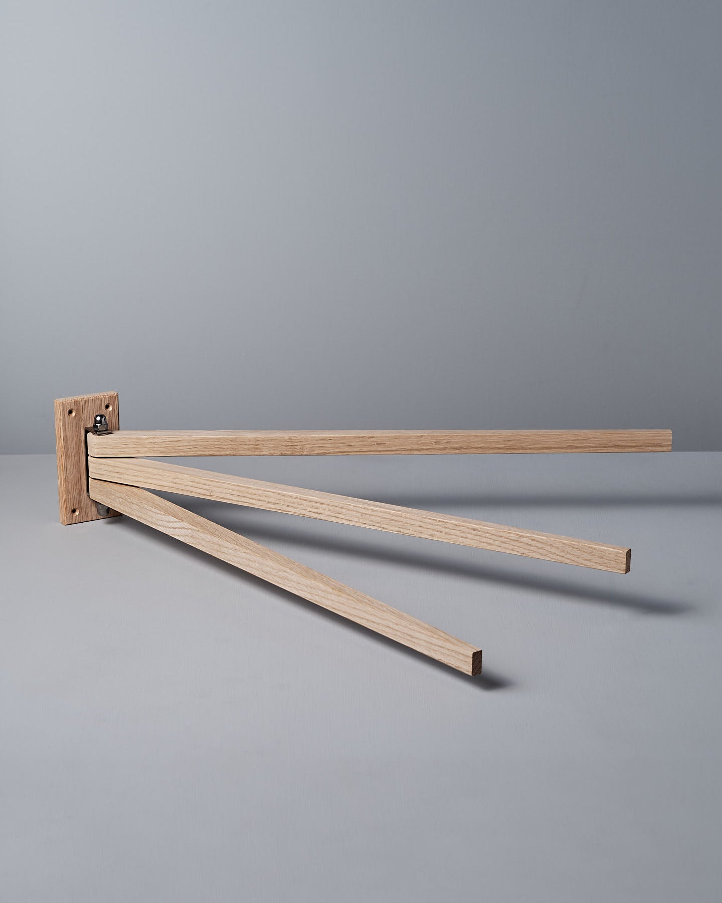 The Oak Towel Drying Rack – 3 Arm by Iris Hantverk showcases an elegant design with three outward-extended horizontal arms, crafted from fine oak to add a touch of natural beauty.