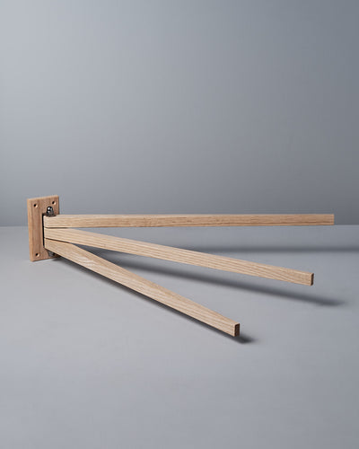 The Oak Towel Drying Rack – 3 Arm by Iris Hantverk showcases an elegant design with three outward-extended horizontal arms, crafted from fine oak to add a touch of natural beauty.