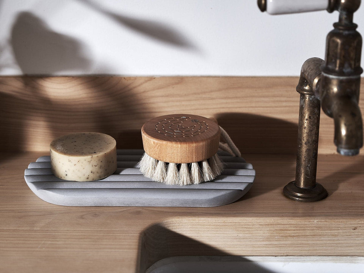 A Iris Hantverk Concrete Tray with a soap brush and soap on it.