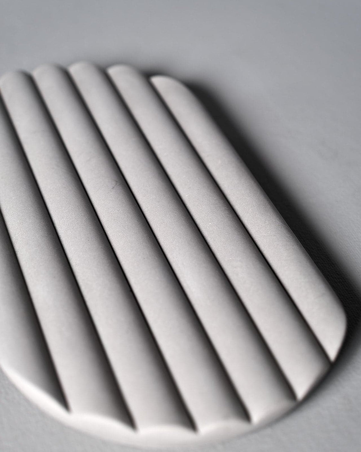 An Iris Hantverk Concrete Tray with a row of slats on it.