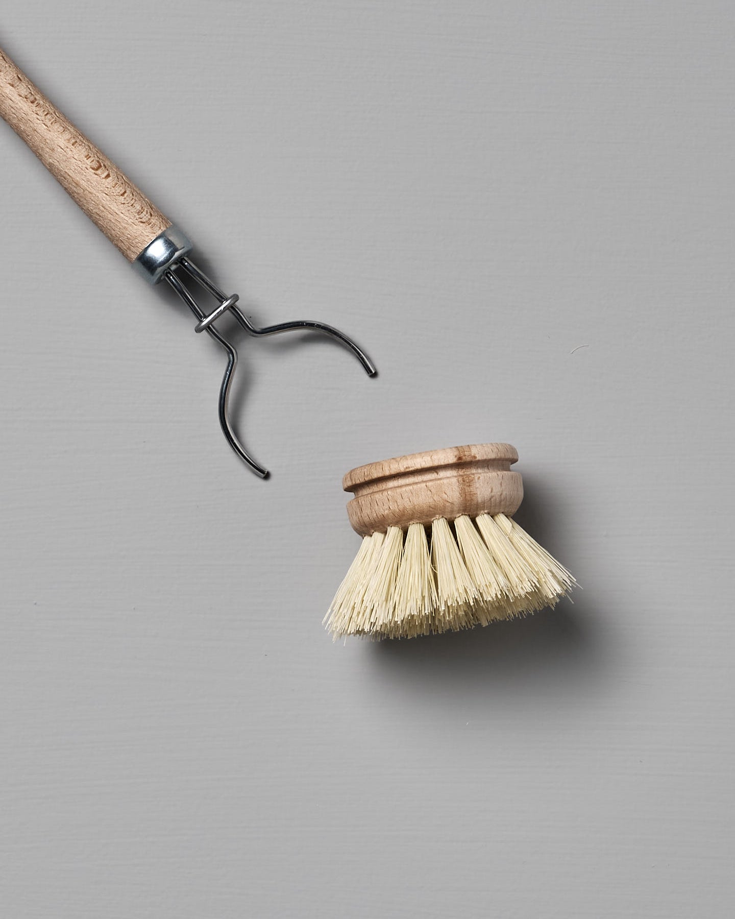 Iris Hantverk's Dish Brush with Replaceable Head featuring a detachable bristle head made from durable Tampico fibre, set against a gray background.