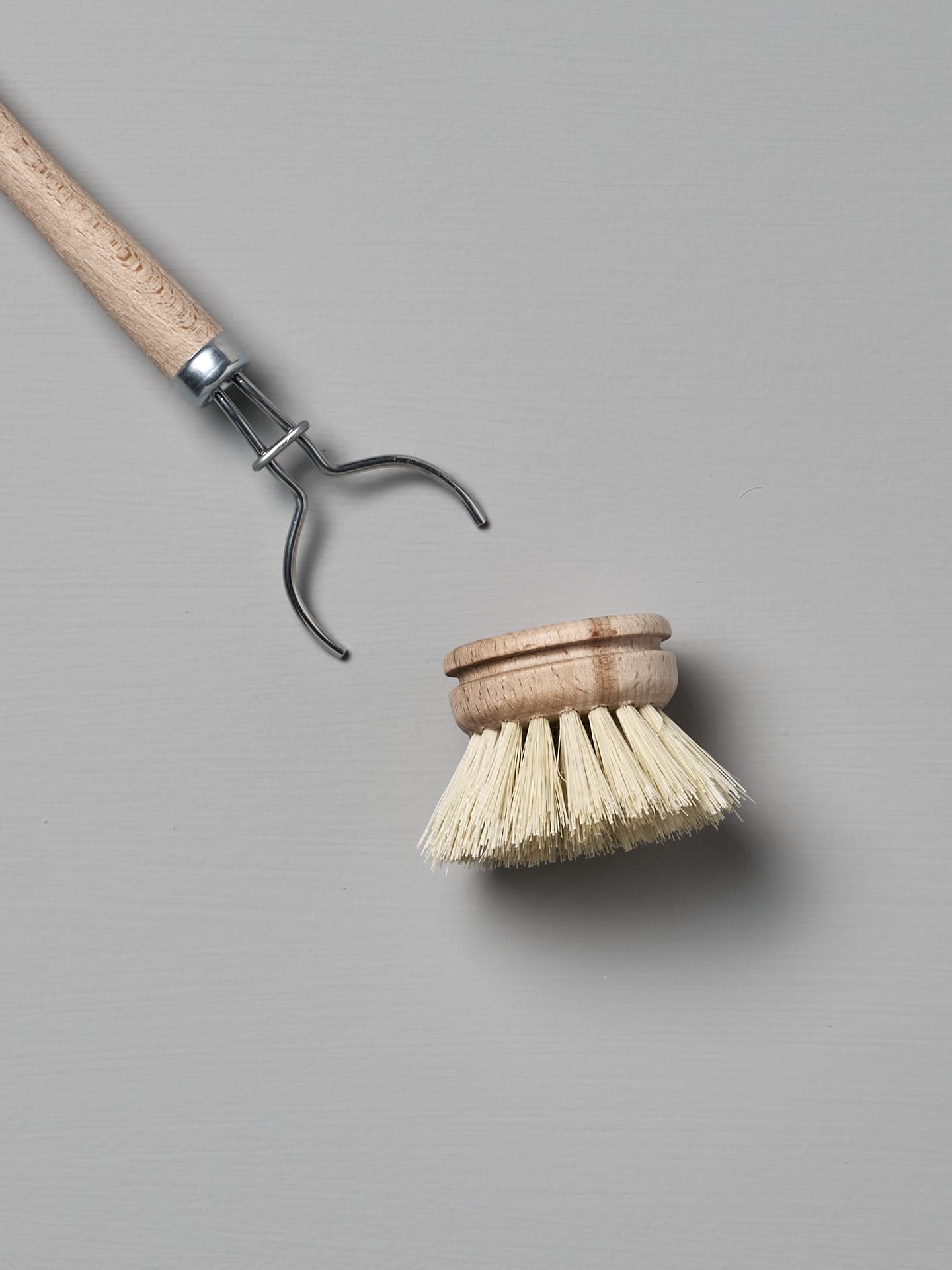 Iris Hantverk's Dish Brush with Replaceable Head featuring a detachable bristle head made from durable Tampico fibre, set against a gray background.