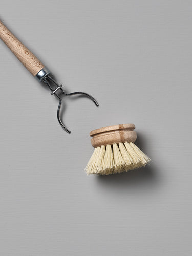 Iris Hantverk's Dish Brush with Replaceable Head featuring a detachable bristle head made from durable Tampico fibre, set against a gray background.