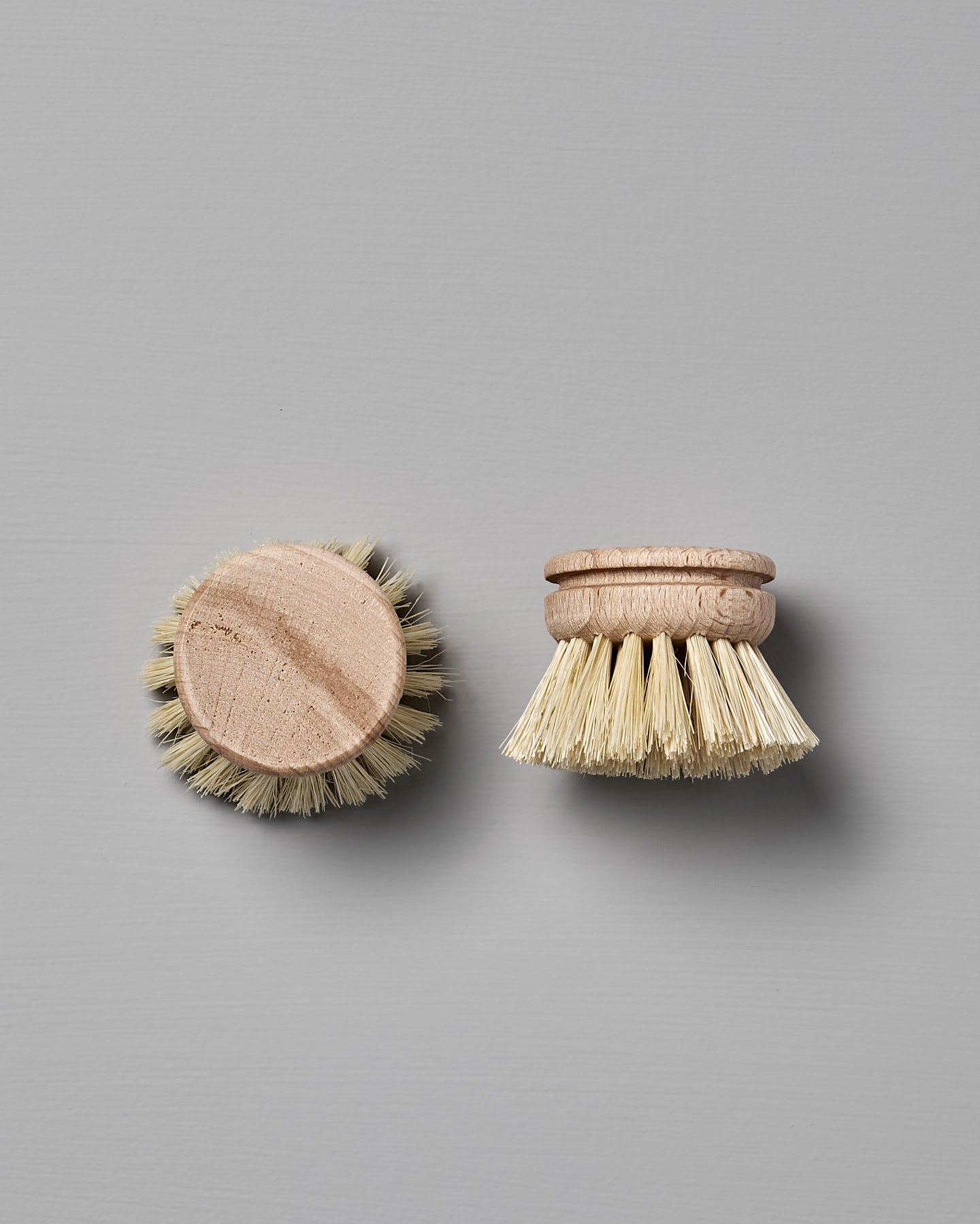 Iris Hantverk's Dish Brush with Replaceable Head featuring a detachable bristle head made from durable Tampico fibre, set against a gray background.
