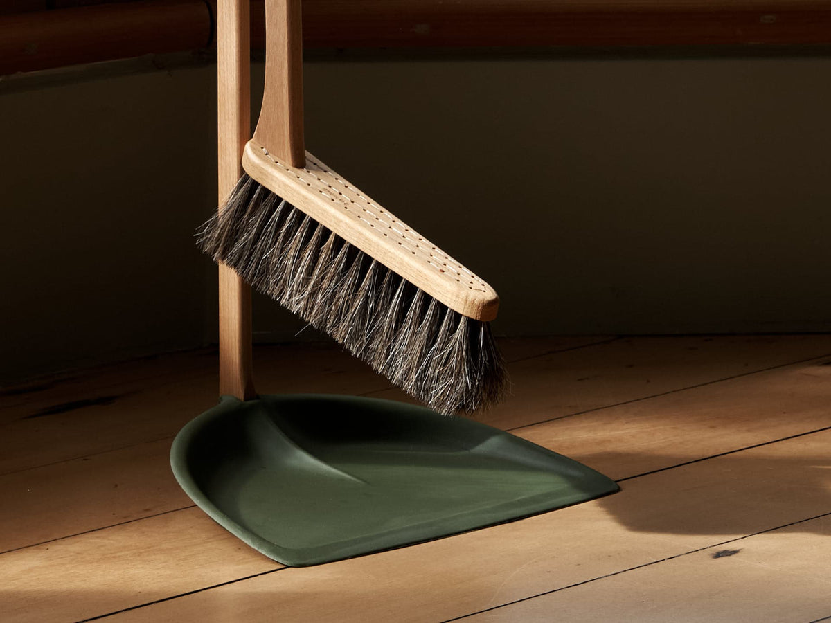 A Long Handled Dustpan &amp; Brush Set – Moss Green by Iris Hantverk stands on a wooden floor.