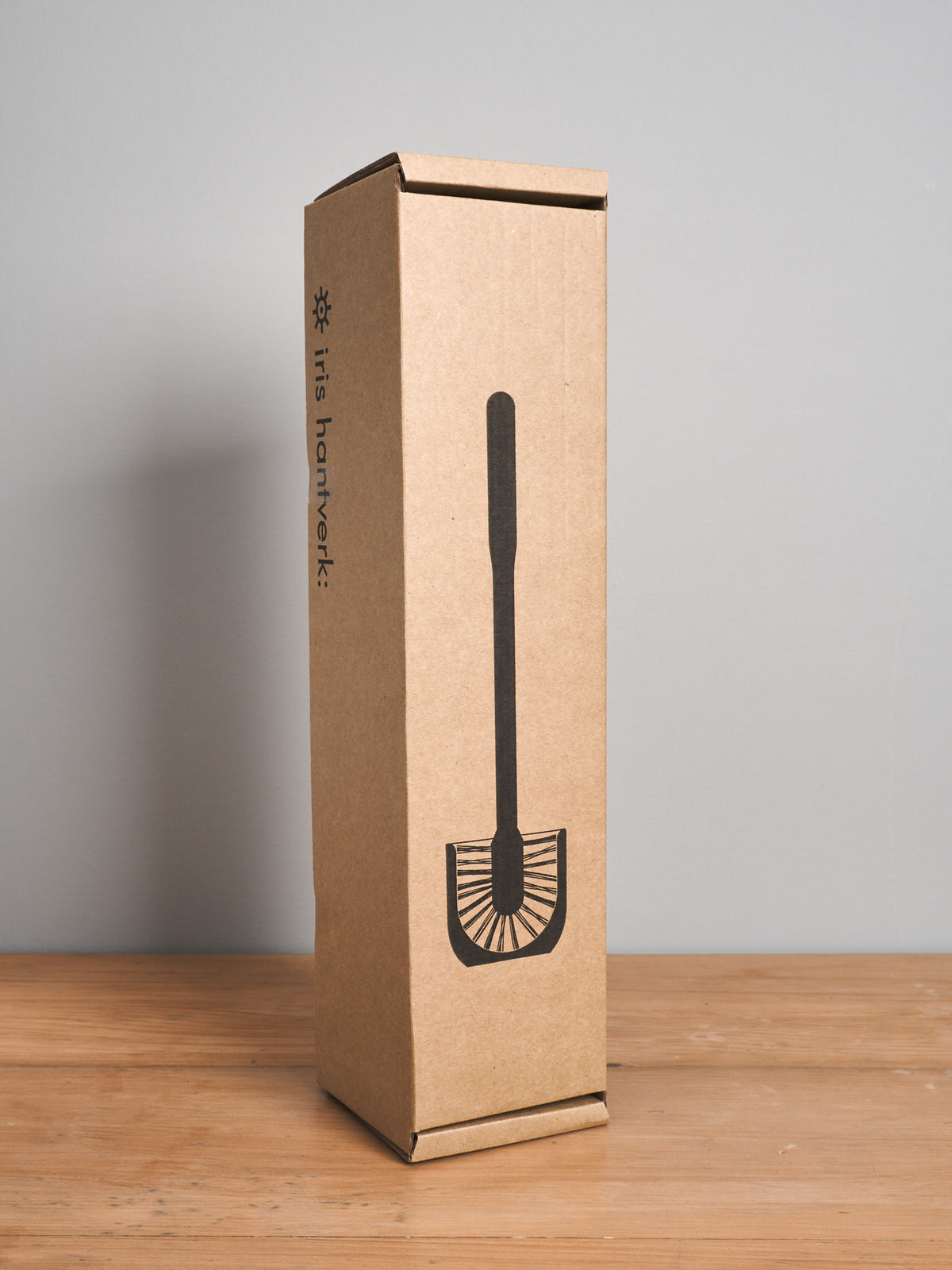 A cardboard Iris Hantverk product box with an image of a Iris Hantverk Toilet Brush + Toilet Roll Holder Set and the text &quot;#itsframework&quot; displayed on the side.