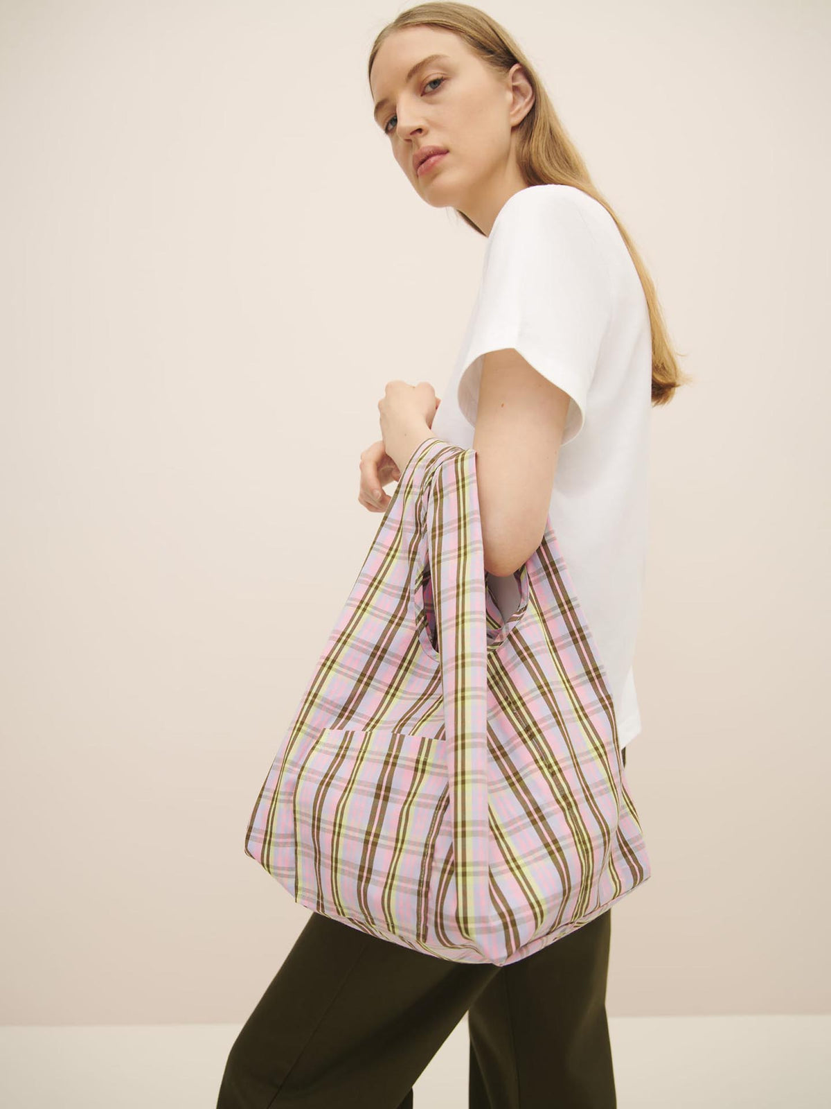 Woman posing with a Mini Market Bag – Pink Tartan by Kowtow.