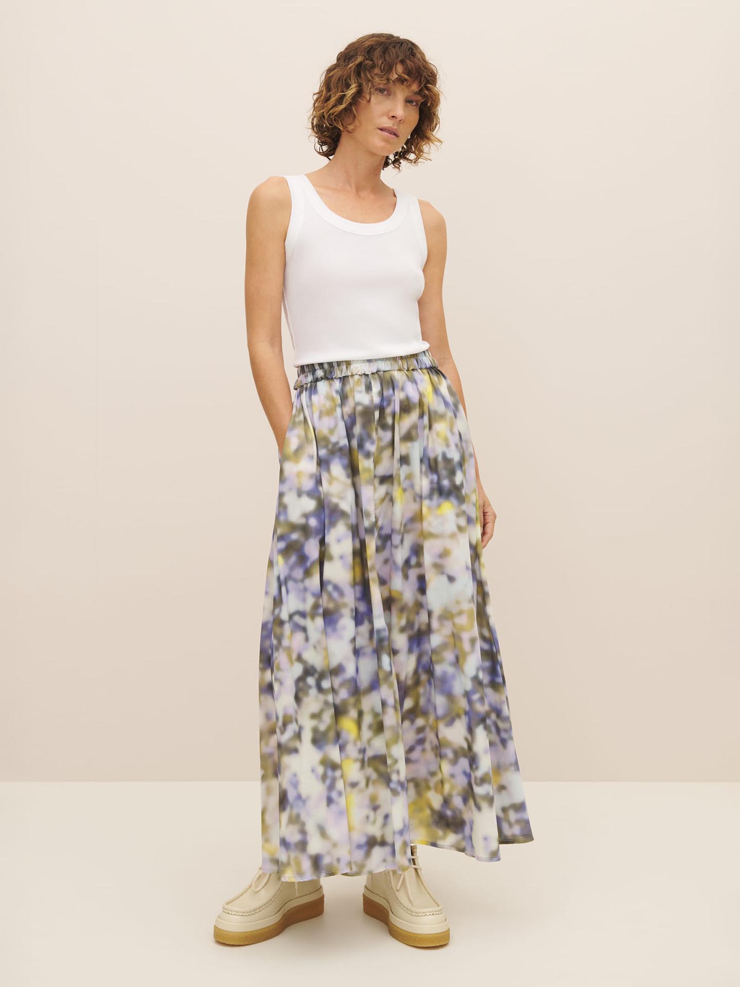 A woman in a lightweight organic cotton voile floral Muse Skirt – Komorebi by Kowtow.