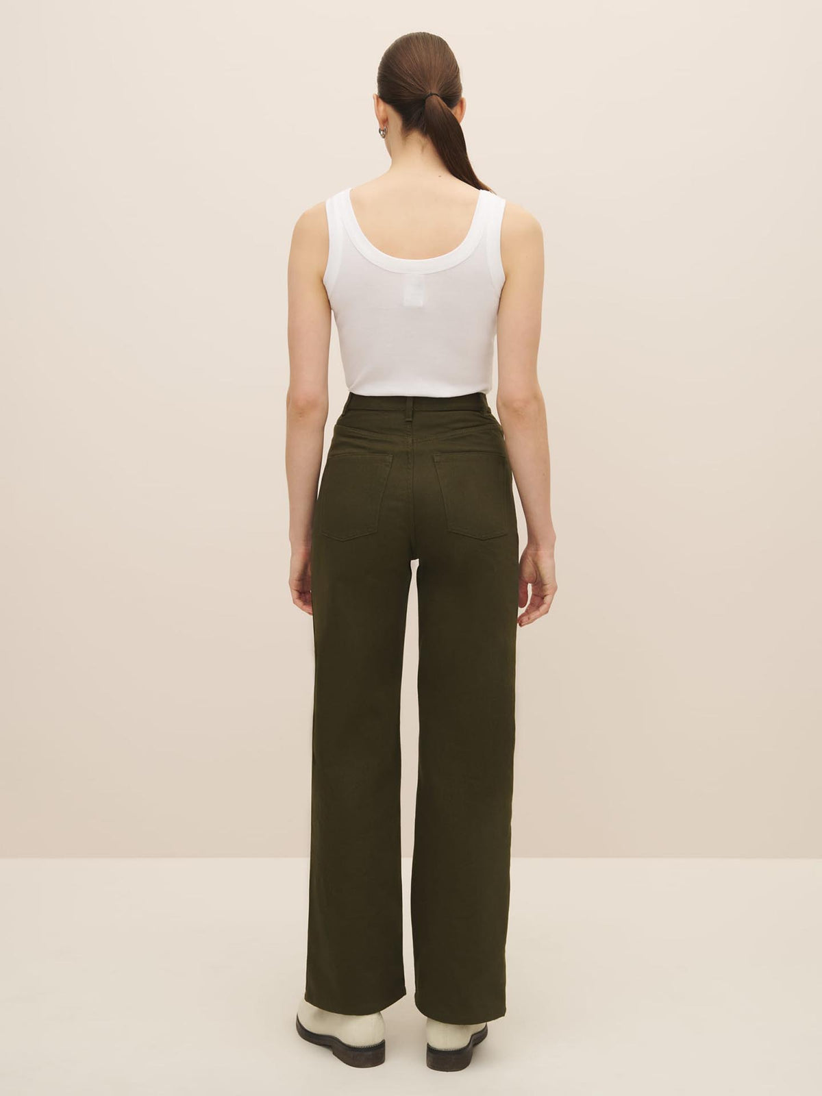 The back view of a woman wearing Straight Leg Jeans – Khaki Denim in olive green, made from organic cotton by Kowtow.