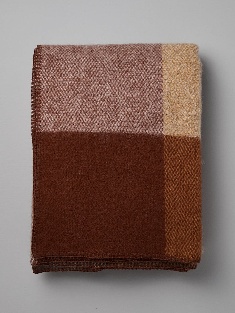 Klippan's Block Wool Throw – Rust, featuring a color-block design in shades of brown, beige, and cream, made from eco-friendly wool.
