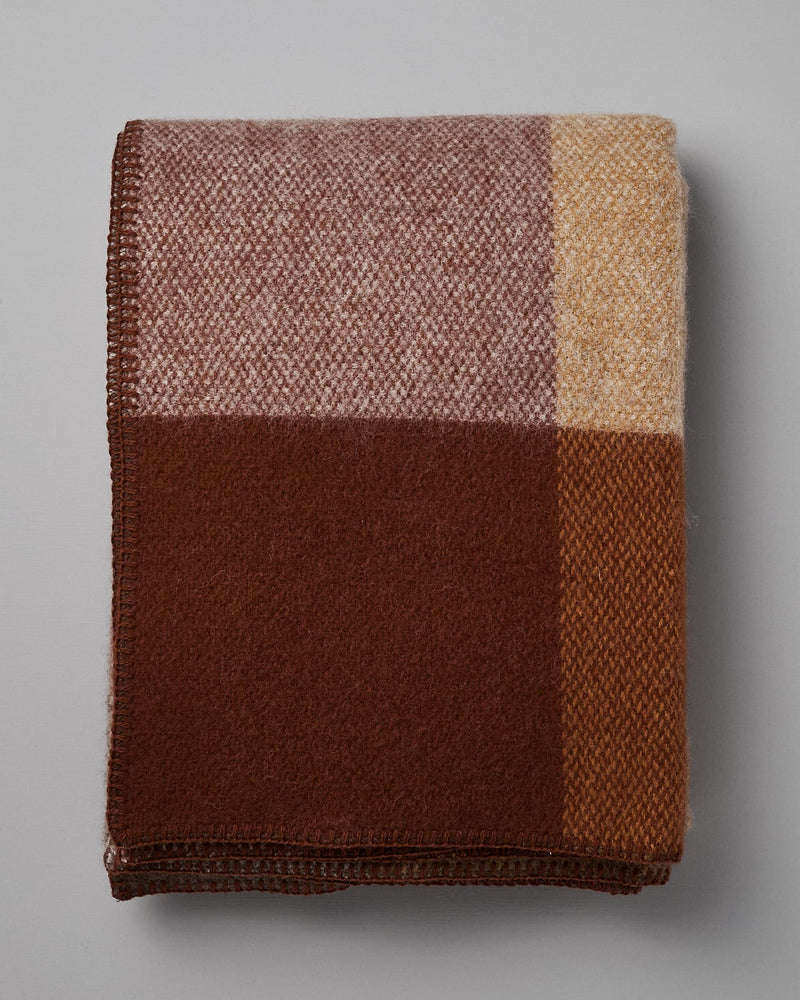 Klippan's Block Wool Throw – Rust, featuring a color-block design in shades of brown, beige, and cream, made from eco-friendly wool.