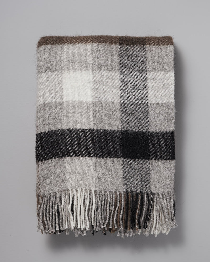 A Klippan Gotland Wool Throw – Multi Grey on a grey background.