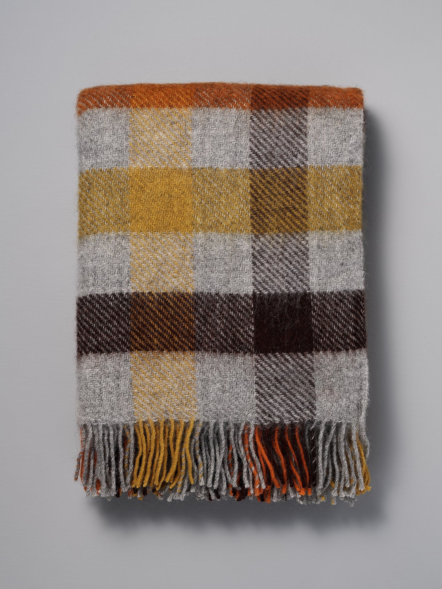 A Klippan Gotland Wool Throw – Multi Yellow plaid throw on a white background.