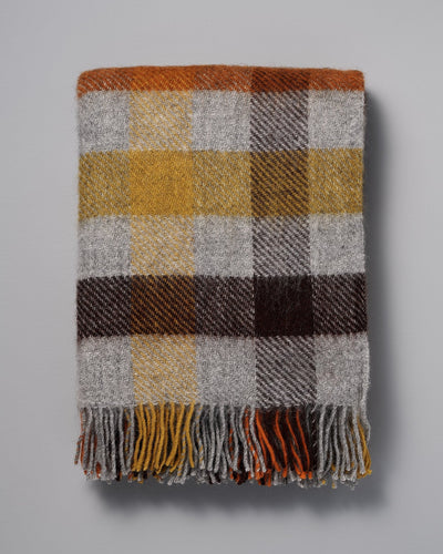 A Klippan Gotland Wool Throw – Multi Yellow plaid throw on a white background.