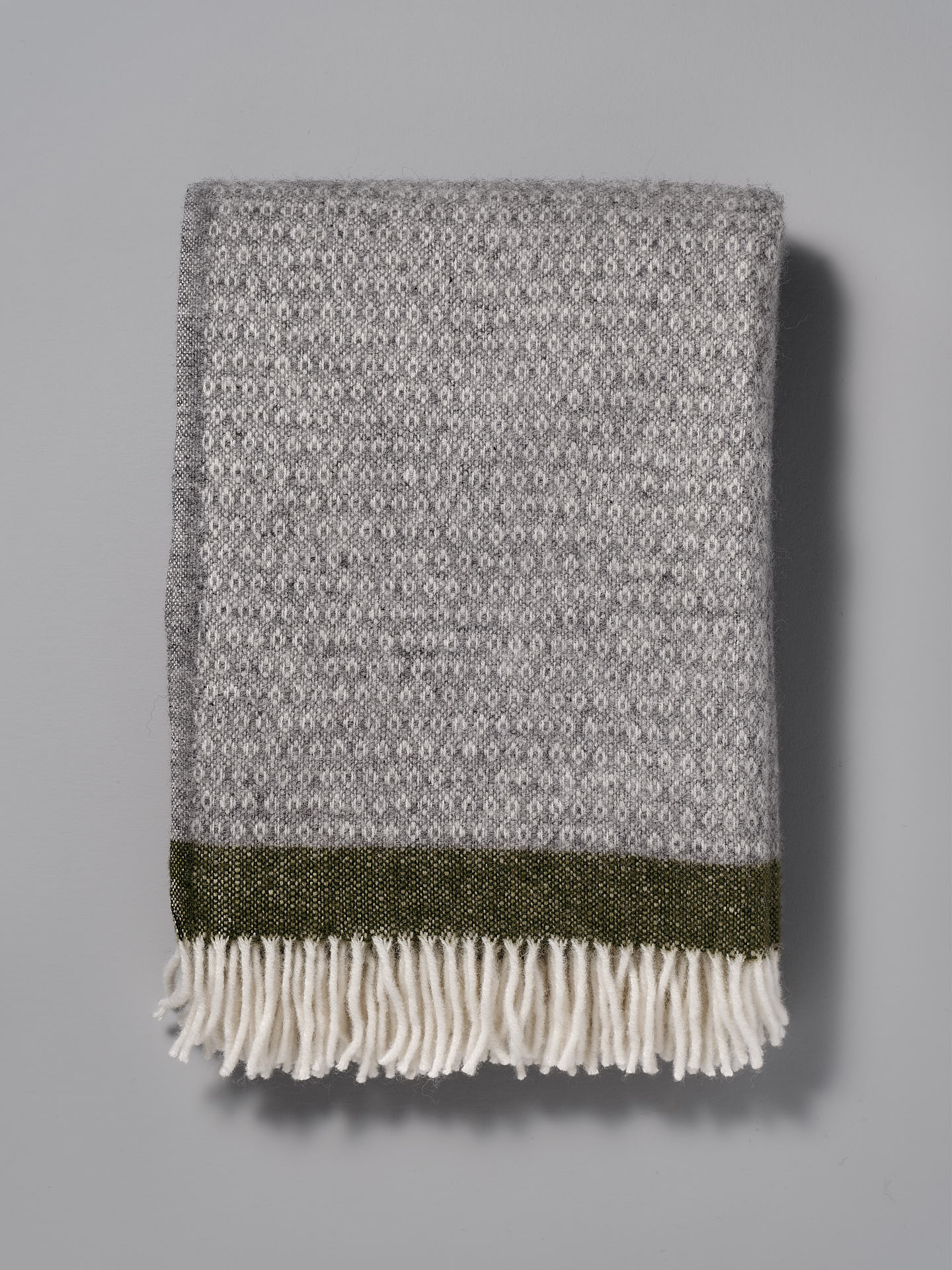 A Klippan Hampus Wool Throw - Grey Green with fringes.