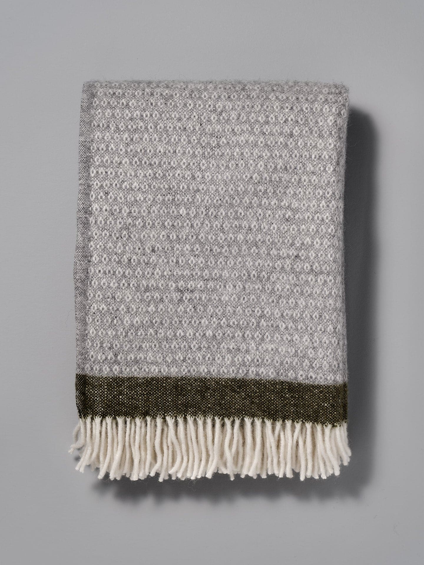A Klippan Hampus Wool Throw - Grey Green with fringes.