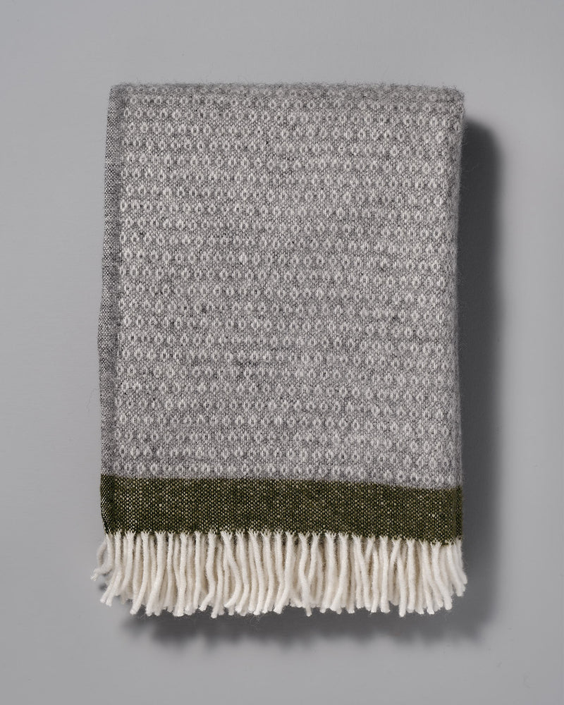 A Klippan Hampus Wool Throw - Grey Green with fringes.