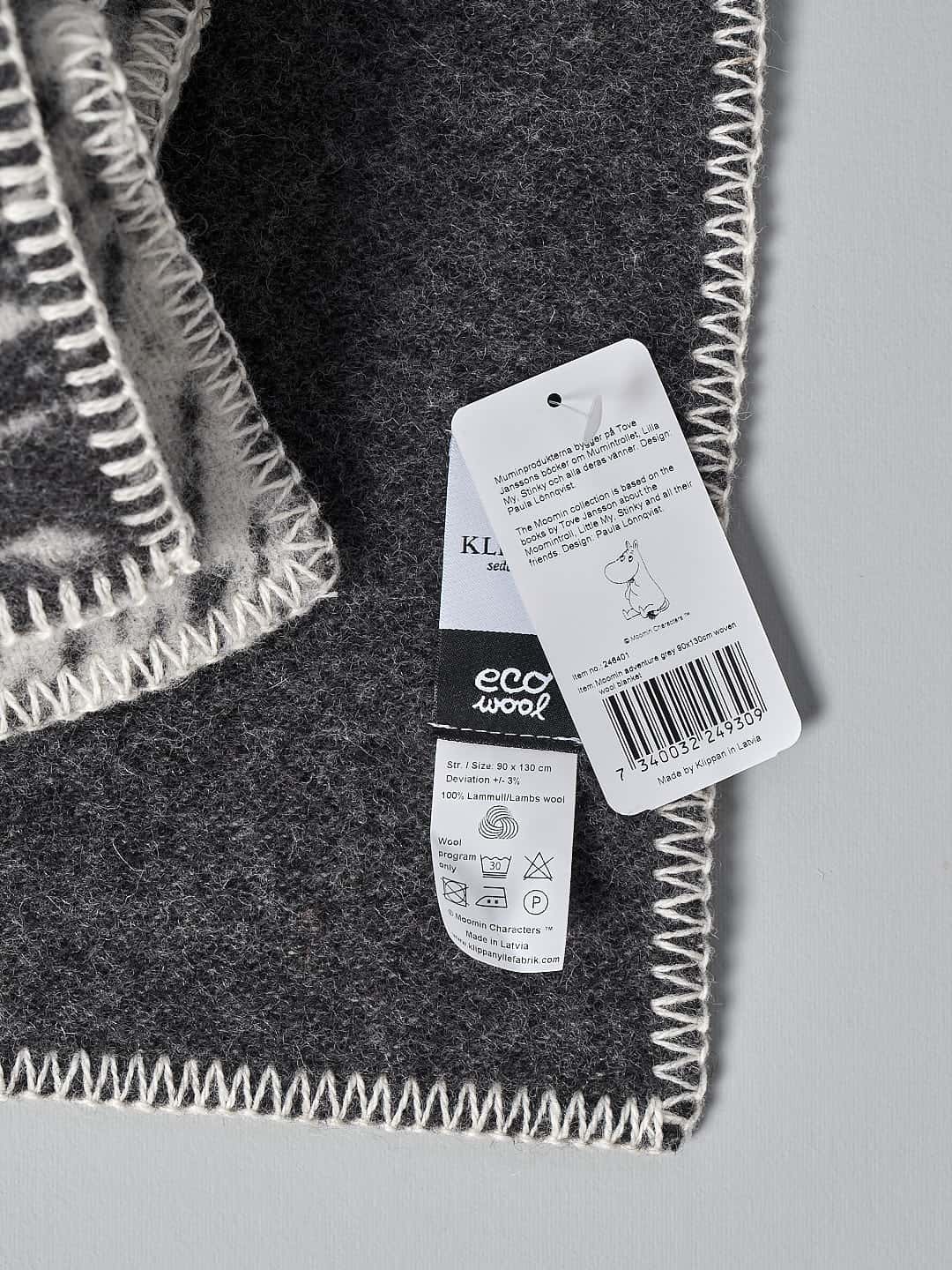 A black and white Moomin Childs Blanket – Camp Adventure with a Klippan tag on it.