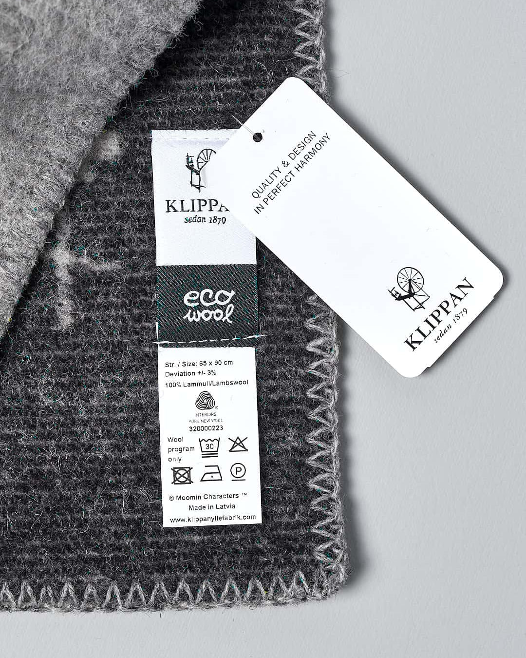 A Klippan Moomin Baby Blanket - Tree Hug with a tag on it.