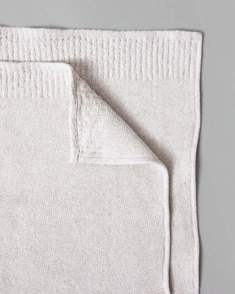 Kontex's Re.Lana Towels, crafted in beige from 100% cotton, folded on a gray surface.