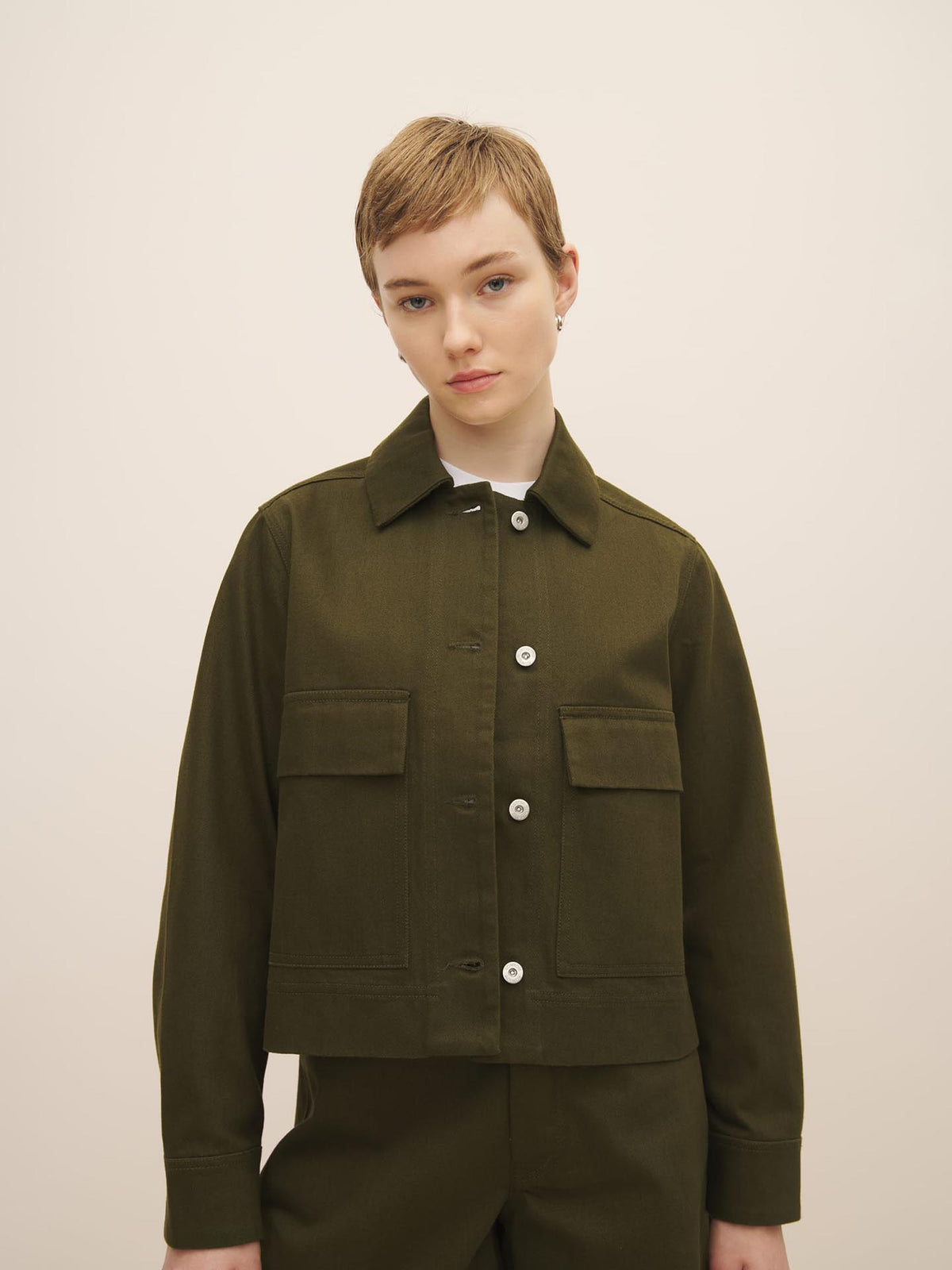 Woman in a Kowtow Mirror Jacket – Khaki Denim with a perfect fit and a collar, posing against a neutral background.