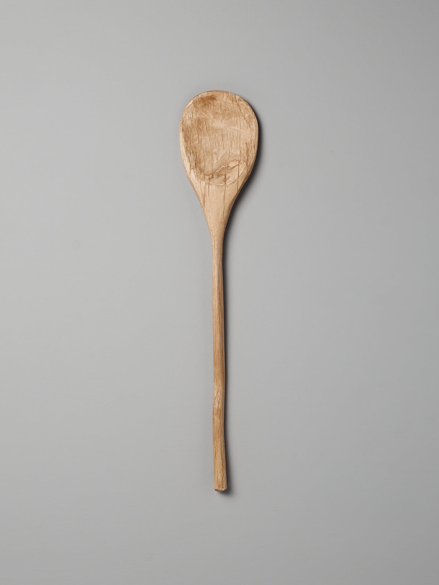 The Paddle Spoon by Luke Crouch, featuring a long handle and an oval-shaped bowl crafted from Australian She-Oak, is set against a plain gray background.