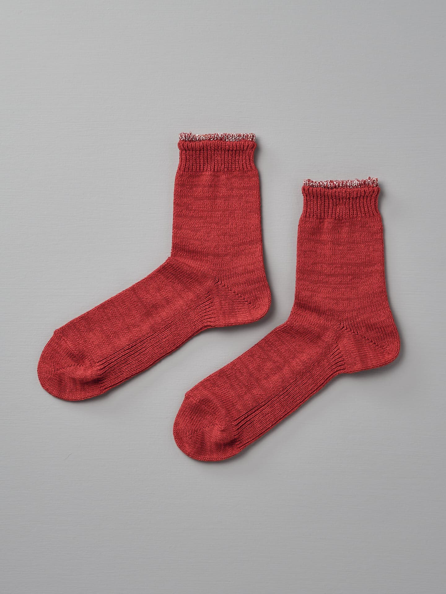 A pair of Mauna Kea Organic Top Switching Socks – Red, available in sizes EUR 35—38, is laid out on a gray surface.