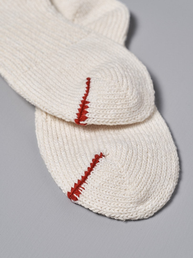 A pair of Mauna Kea Japanese Slub, Low-Cut Socks – Off White with red stitching.