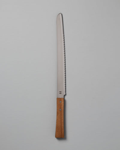 A Morinoki Bread Knife by Shizu Hamono Co., featuring a serrated stainless steel blade and a handle crafted from exquisite Japanese Zelkova wood, set against a plain white background.