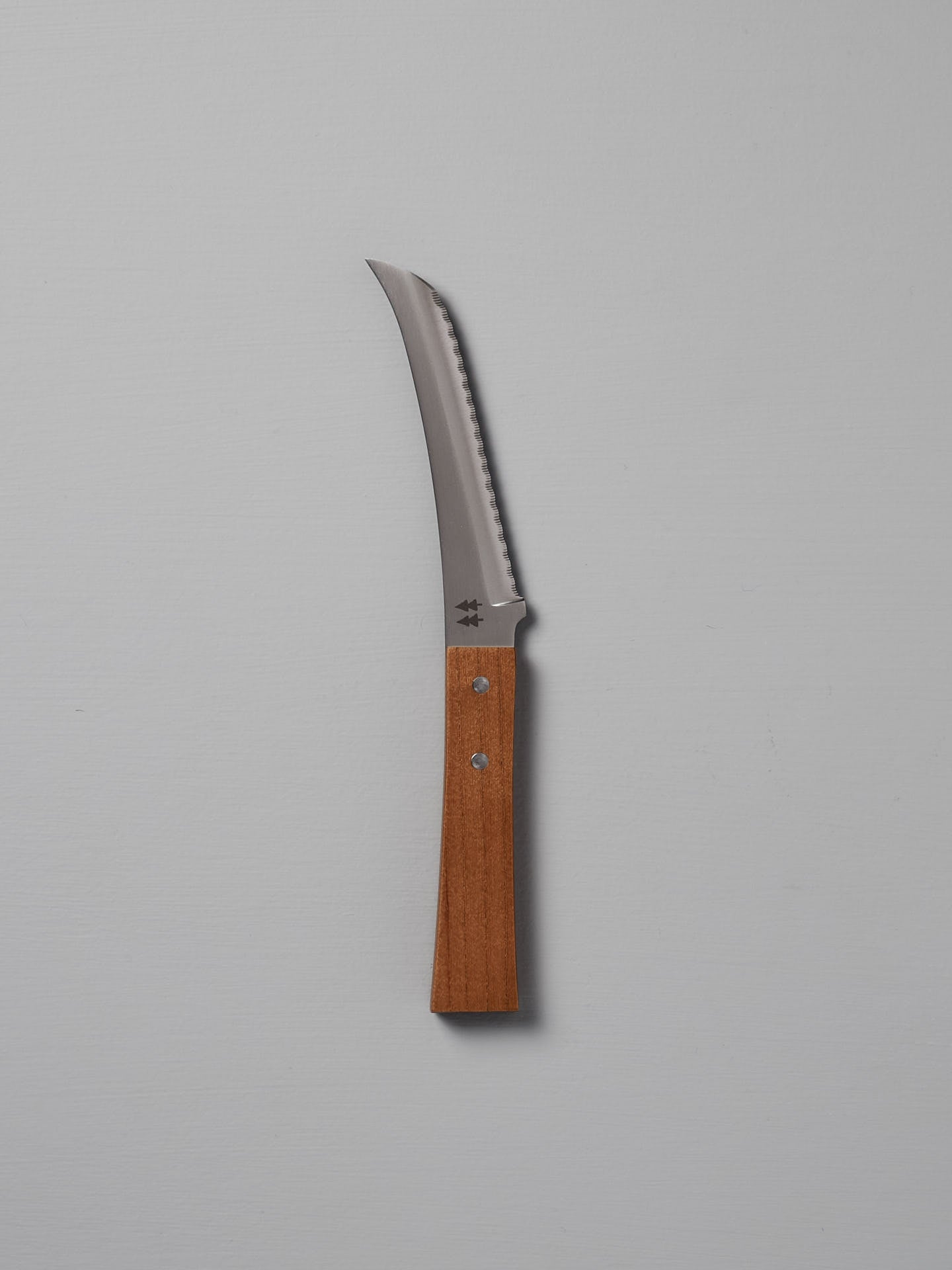 The Morinoki Soft Cheese Knife by Shizu Hamono Co., featuring a serrated blade and Japanese Zelkova handle, is shown vertically against a plain light gray background.