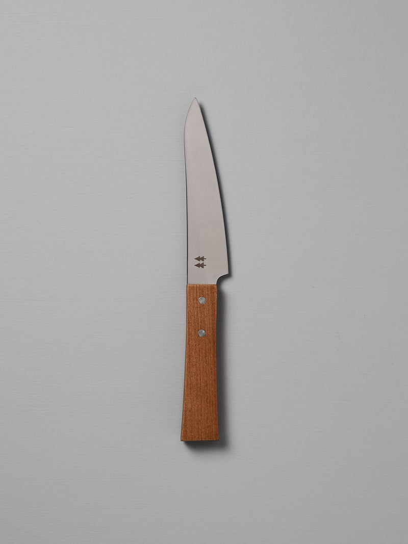 The Morinoki Petite Knife from Shizu Hamono Co. boasts an ergonomic grip and sleek stainless steel blade, complemented by a wooden handle, elegantly displayed against a light gray background.