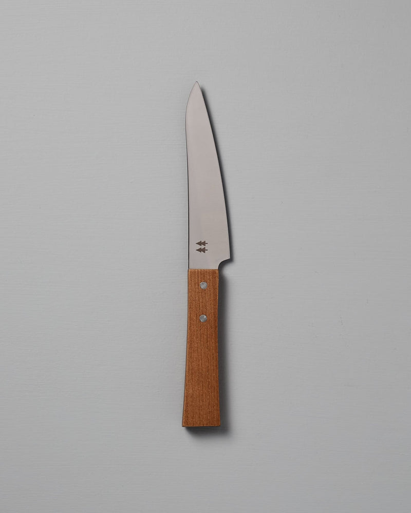 The Morinoki Petite Knife from Shizu Hamono Co. boasts an ergonomic grip and sleek stainless steel blade, complemented by a wooden handle, elegantly displayed against a light gray background.