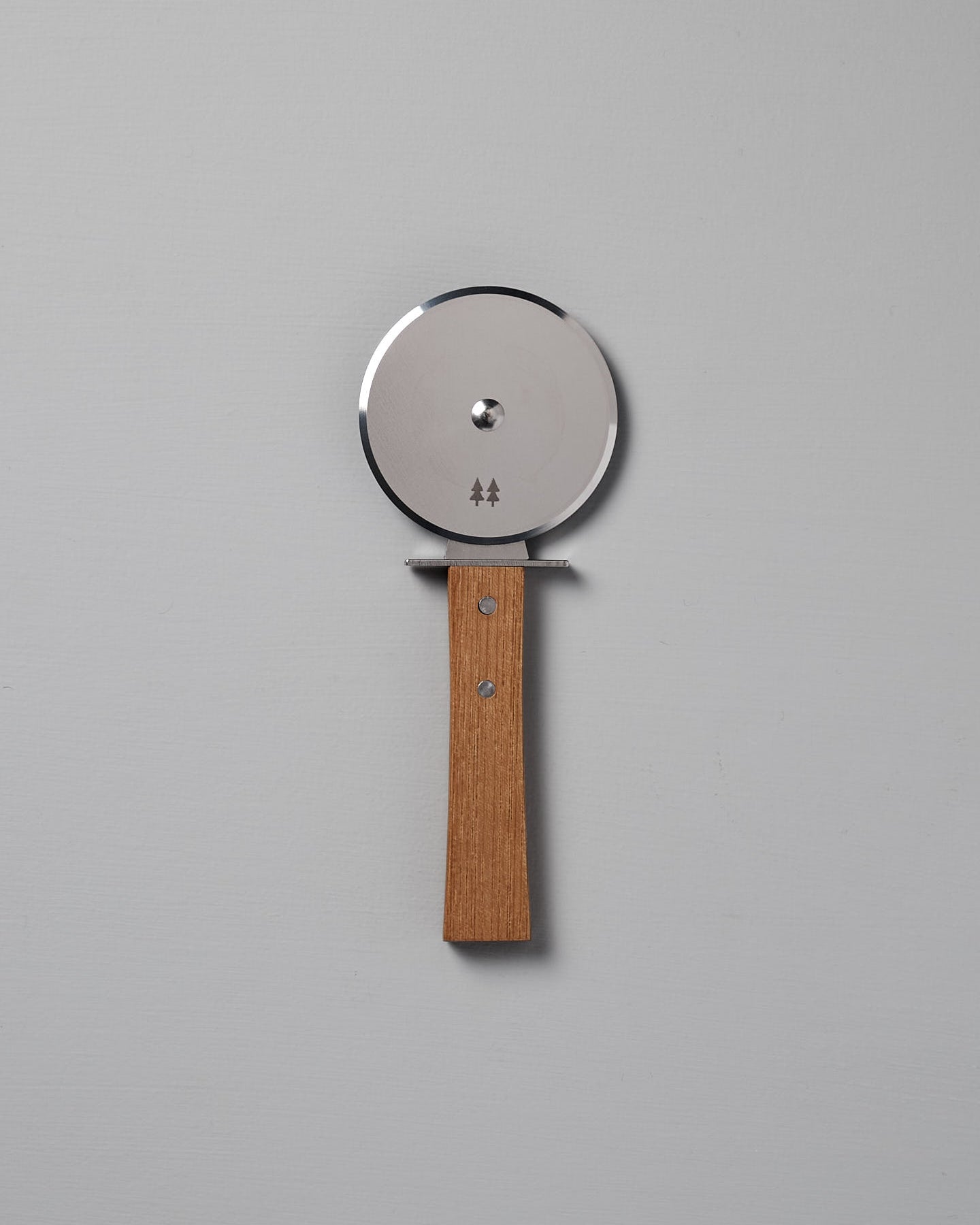 The Morinoki Pizza Wheel by Shizu Hamono Co., featuring a stainless steel blade and Japanese Zelkova handle, is positioned vertically against a plain light gray background.