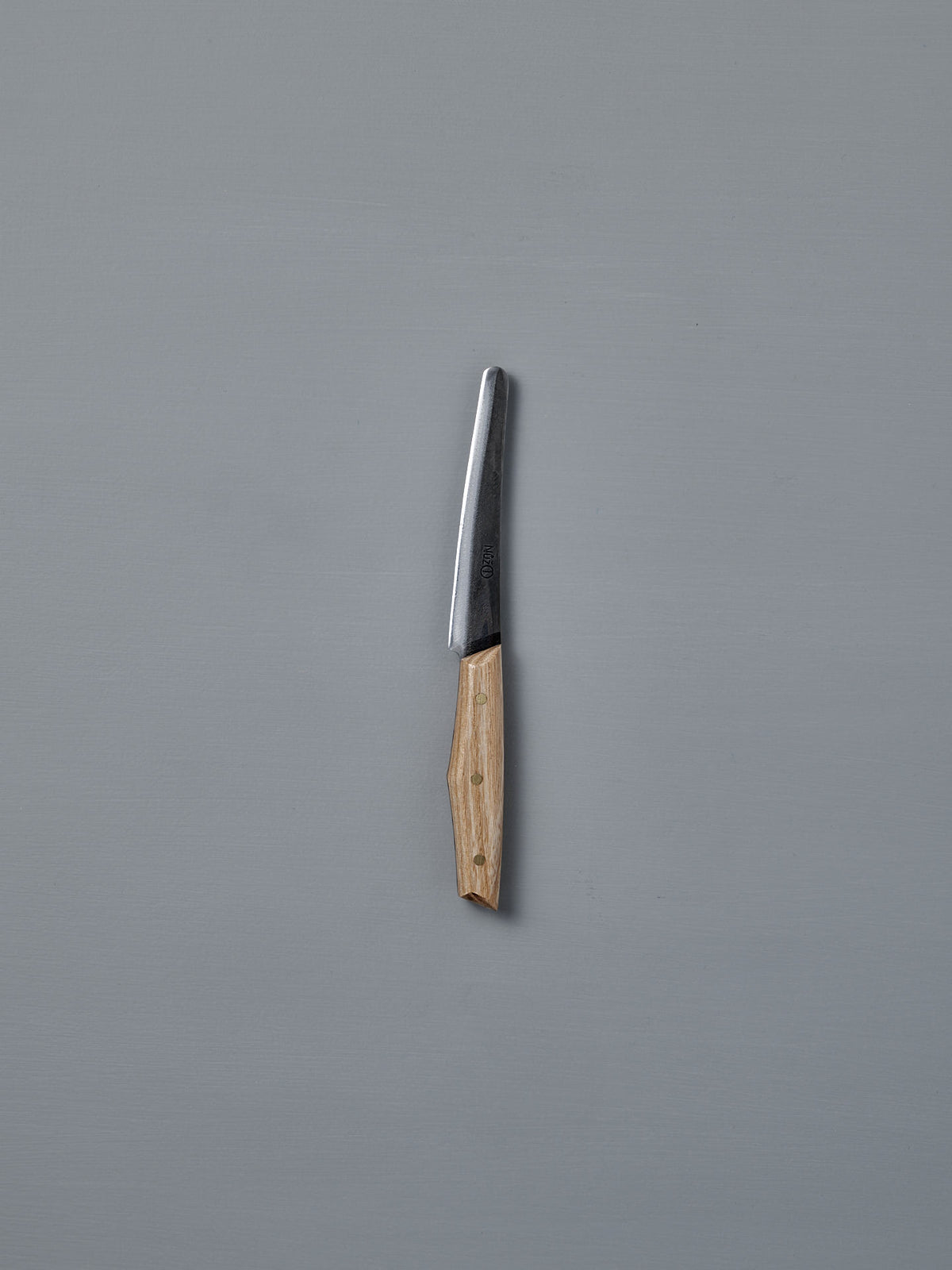 The №1 – Spread Knife, featuring a handcrafted wooden handle and a Swedish carbon steel blade, is displayed vertically against a plain gray background.