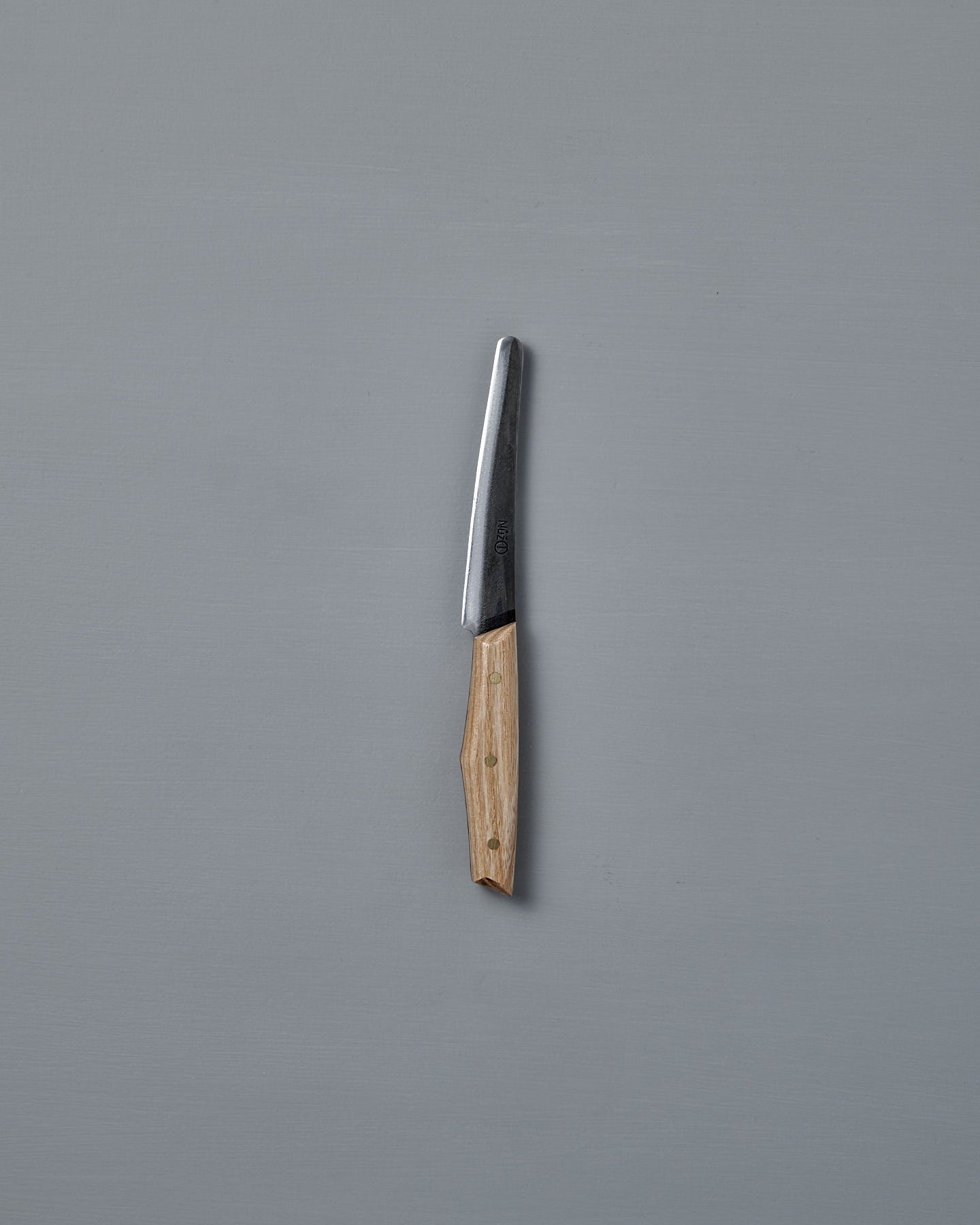 The №1 – Spread Knife, featuring a handcrafted wooden handle and a Swedish carbon steel blade, is displayed vertically against a plain gray background.