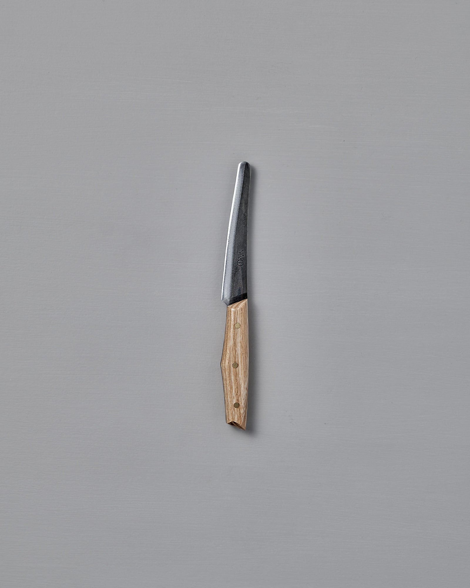 The №1 – Spread Knife, featuring a handcrafted wooden handle and a Swedish carbon steel blade, is displayed vertically against a plain gray background.
