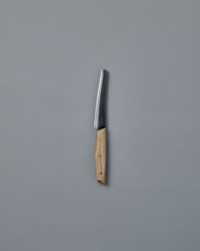 The №1 – Spread Knife, featuring a handcrafted wooden handle and a Swedish carbon steel blade, is displayed vertically against a plain gray background.