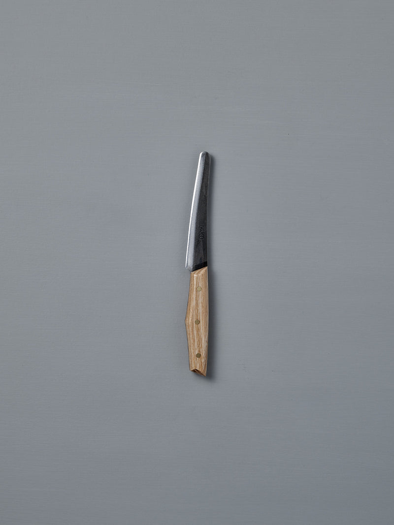 The №1 – Spread Knife, featuring a handcrafted wooden handle and a Swedish carbon steel blade, is displayed vertically against a plain gray background.