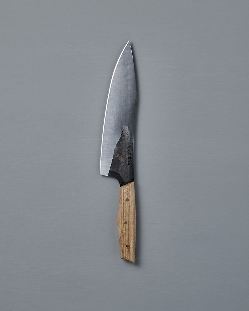 The №3 – Daily Knife, featuring a wide stainless steel blade and wooden handle, rests on a plain gray surface.