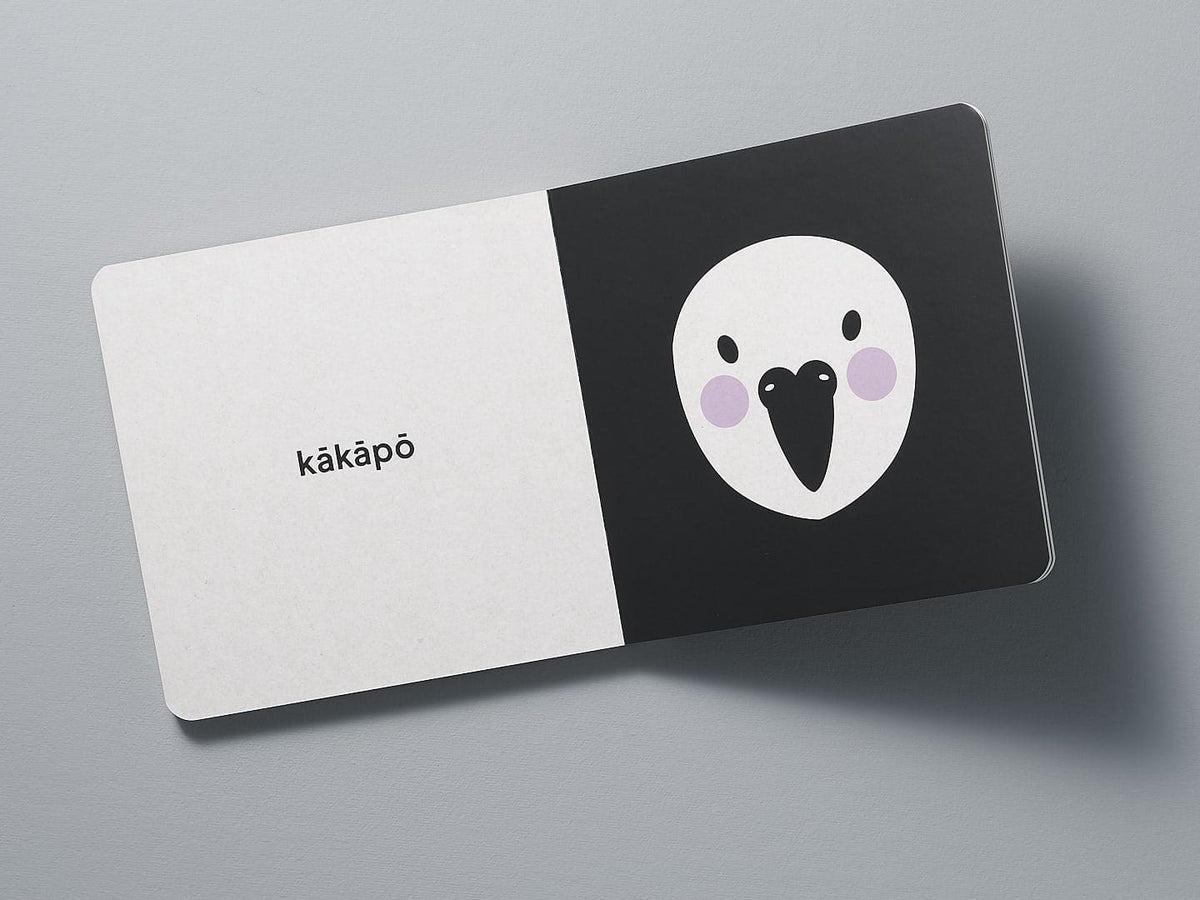A business card with a minimalist Native NZ Baby Meets Bird design, highlighting New Zealand birds, on a gray background by Kate Muir.