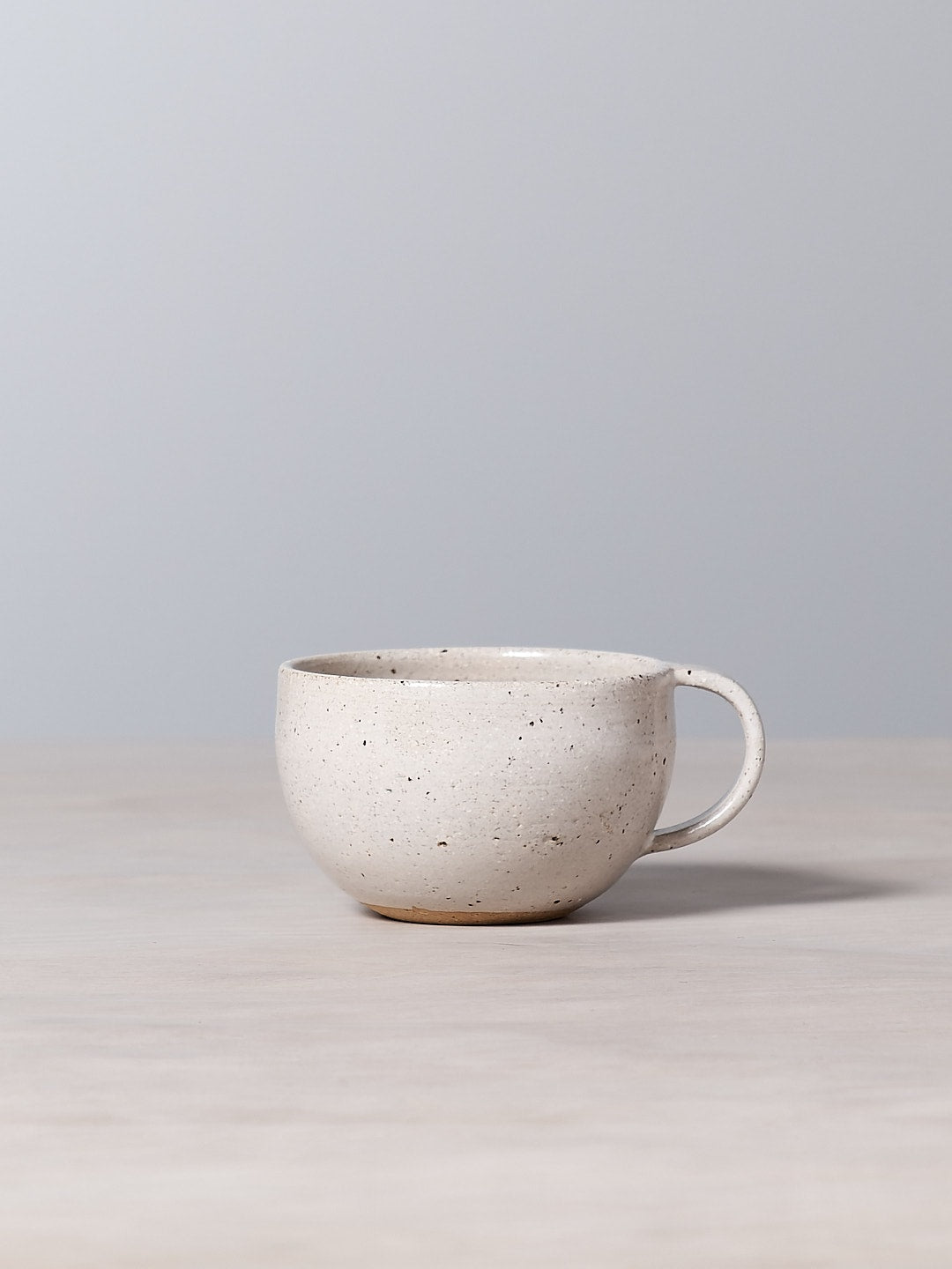 A handmade Speckled cup sitting on a table next to a gray wall. (Nicola Shuttleworth)