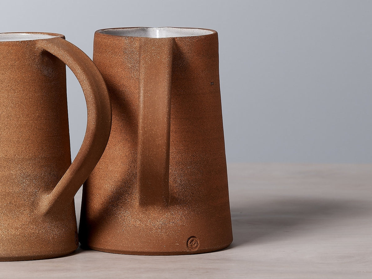 Two Nicola Shuttleworth Textured jugs sitting on a well-balanced table.