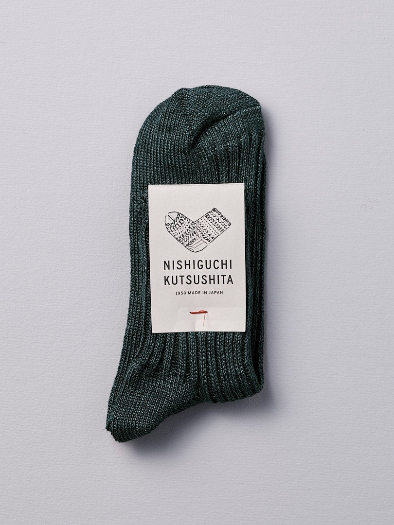 A Nishiguchi Kutsushita Praha Linen Ribbed Socks – Beach Plants with a label on it.